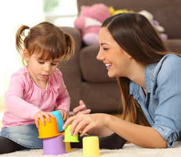 Psychology Professional smiling while helping a kid with blocks