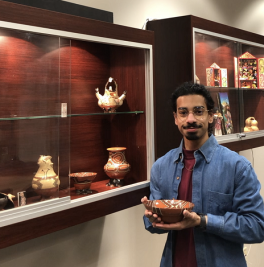 Brandon D'Souza with an artifact from the Andean and Amazonian Indigenous Art and Cultural Artifacts Collection