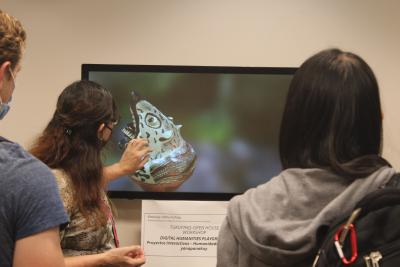 Dr. Wibbelsman using technology to display a cultural artifact from the collection