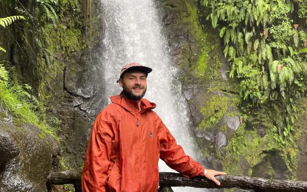 Student posing in front of waterfall