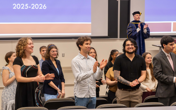 2025-2026 graduates standing in front of stage