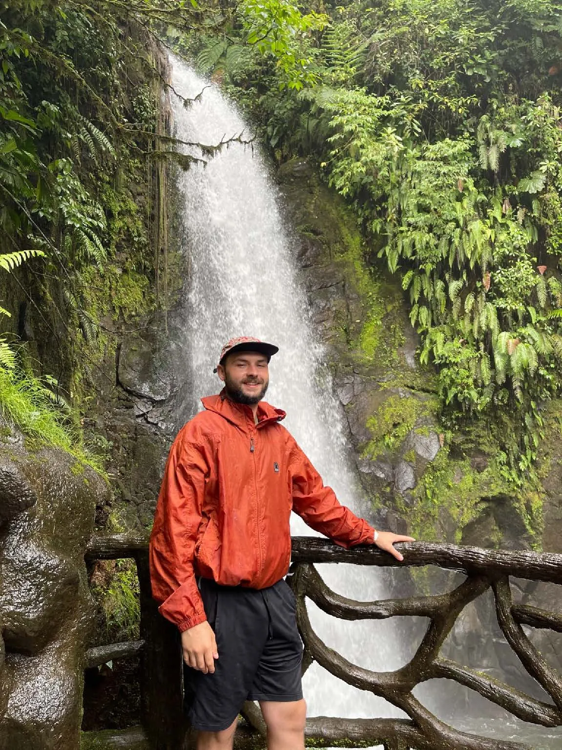 Student posing in front of waterfall